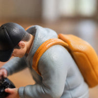 Orange Backpack Bending Male Figurine Light Blue Top Collectible Figure Display Piece for Collectors